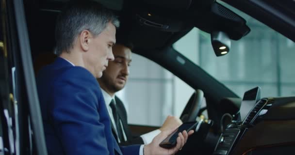 Client et concessionnaire connectant le smartphone à la voiture — Video