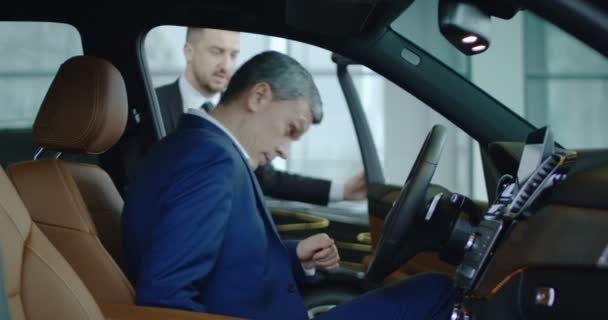 Concessionnaire automobile montrant la voiture au client — Video