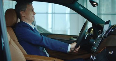 Yeni arabada oturan işadamı ayarlar