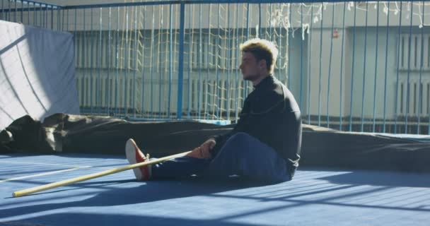 Спортсмен відпочиває на підлозі в залі — стокове відео