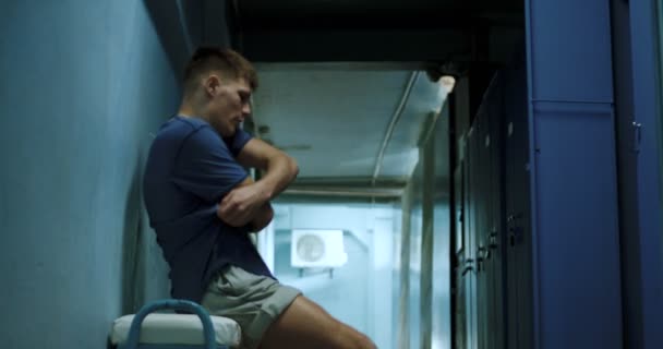 Спортсмен раздевается в раздевалке — стоковое видео