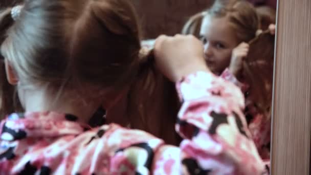 Κορίτσι κάνοντας κοτσιδάκια μπροστά από καθρέφτη — Αρχείο Βίντεο