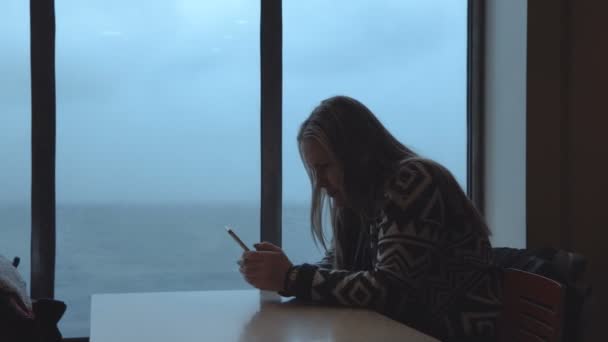 Женщина, использующая телефон в кабине корабля — стоковое видео