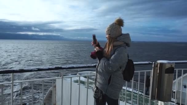 Женщина фотографирует замерзшее море с корабля — стоковое видео