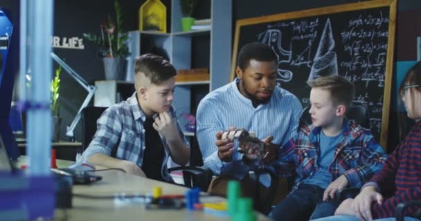 Mann mit Kindern erkundet mechanische Papphand — Stockvideo