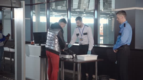 Wachmann kontrolliert Passagiertasche am Flughafen — Stockvideo