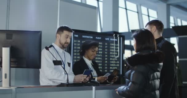 Сотрудники аэропорта проверяют документы на контрольном пункте — стоковое видео