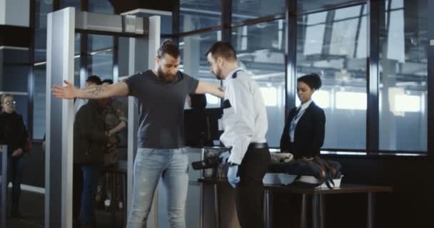 Säkerhetsagenten klappa ner en manlig passagerare — Stockvideo