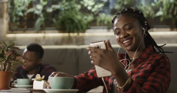 Wanita kulit hitam muda memiliki videocall melalui smartphone — Stok Video