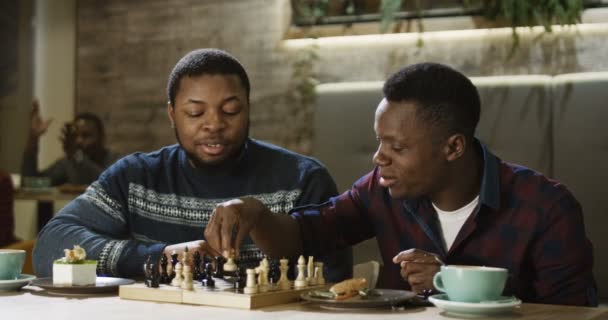 Contenu hommes noirs jouant aux échecs à la cafétéria — Video