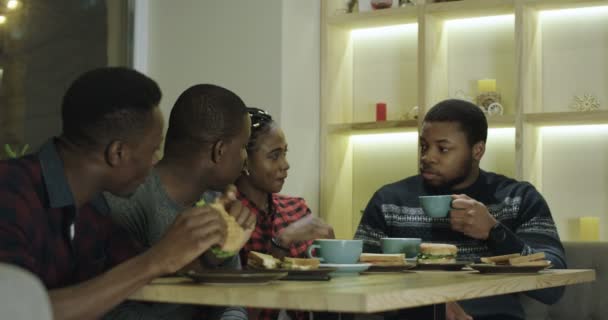 Negro alegres amigos disfrutando de la reunión en la cafetería — Vídeos de Stock