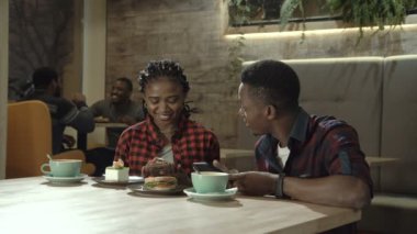 Genç siyah çift bir kafede içecekler yemek
