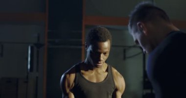 Siyah adam ağırlık kaldırma sırasında yardımcı antrenör