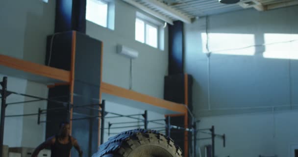 Adam büyük lastik üzerinde eğitim sırasında atlama — Stok video