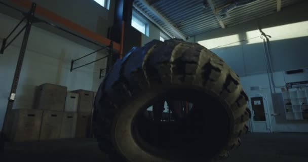 Hombre tirando de neumáticos grandes en el entrenamiento crossfit — Vídeos de Stock