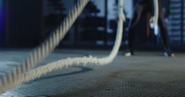 Ağır ipleri egzersiz yaparak sallayarak güçlü sporcu