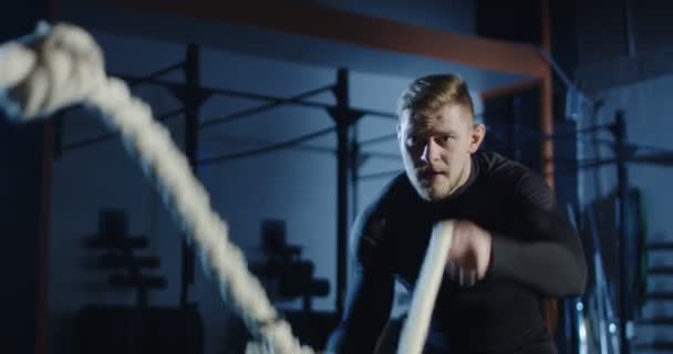 Спортсмен тренируется с тяжелыми канатами в тренажерном зале — стоковое видео