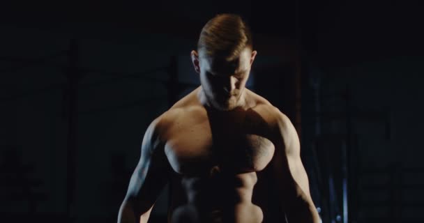 Muscular man exercising with dumbbells at gym — Stock Video