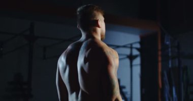 Spor salonunda halterle egzersiz yapan bir adam.