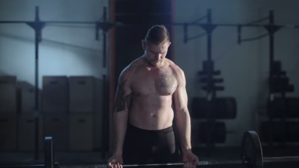 Татуированный спортсмен поднимает штангу в спортзале — стоковое видео
