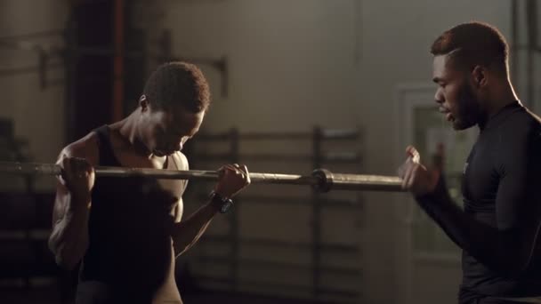 Atlético hombres negros haciendo ejercicio en el gimnasio juntos — Vídeos de Stock