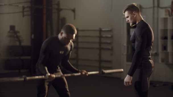 Черный человек делает кроссфит с личным тренером — стоковое видео