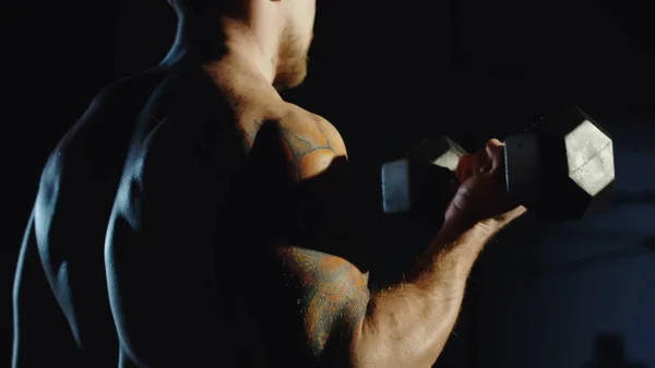 Muskularny mężczyzna ćwiczenia z hantlami na siłowni — Zdjęcie stockowe