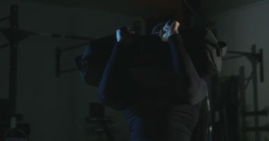 Kum torbası içinde jimnastik salonu ile eğitim adam