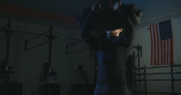 Homem de treinamento com sandbag no ginásio — Vídeo de Stock