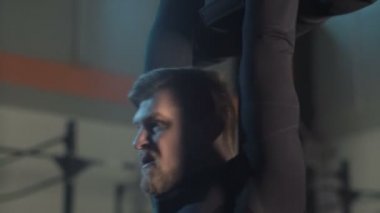 Kaslı adam kum torbası içinde jimnastik salonu ile eğitim