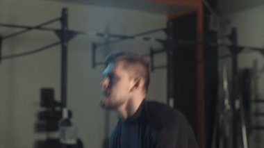 Kaslı adam kum torbası içinde jimnastik salonu ile eğitim