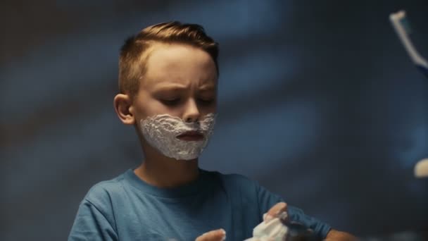 Pequeño niño serio aplicando espuma de afeitar — Vídeos de Stock