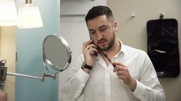 Occupato uomo d'affari che parla al telefono mentre si lava i denti — Video Stock