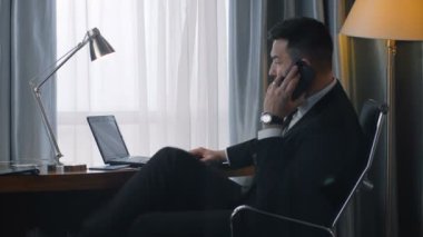 Şık işadamı telefon ve dizüstü bilgisayar kullanarak