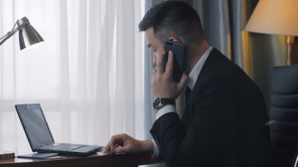 Homem de negócios elegante usando telefone e laptop — Vídeo de Stock