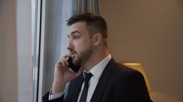 Confident businessman having phone call in hotel — Stock Video