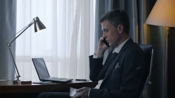 Volwassen zakenman met behulp van de telefoon en laptop — Stockvideo