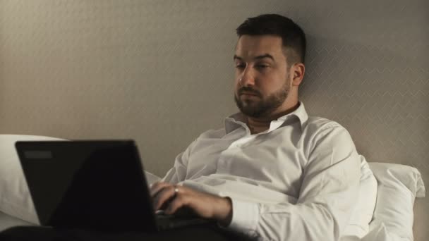 Geschäftsmann arbeitet mit Gadgets im Bett — Stockvideo