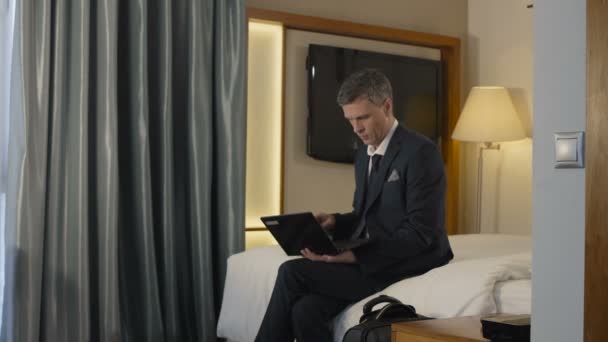 Uomo d'affari che lascia la camera d'albergo con valigia — Video Stock