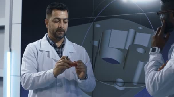 Inventores explorando el modelo de artículo impreso 3-D — Vídeo de stock