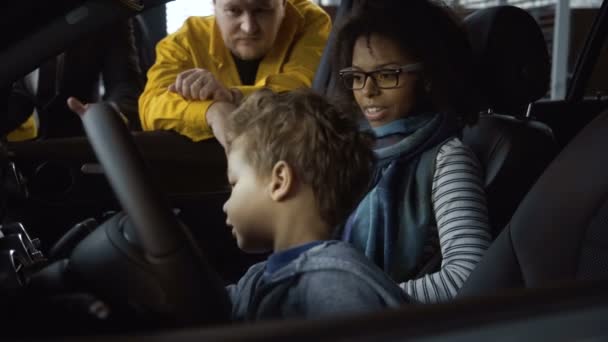 Skiftande familj testar ny bil i salong — Stockvideo