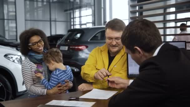 Pareja multiétnica comprando coche en el salón — Vídeo de stock