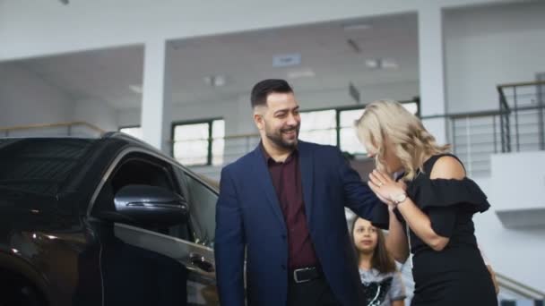 Familia feliz conseguir coche nuevo en el salón — Vídeo de stock