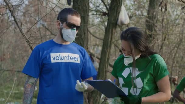 Voluntário conversando com coordenador durante o trabalho — Vídeo de Stock