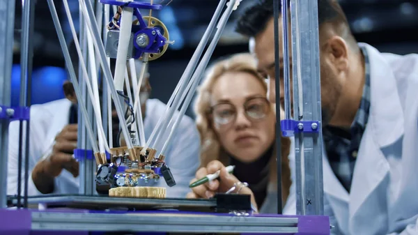 Исследователи наблюдают за процессом 3D-печати — стоковое фото