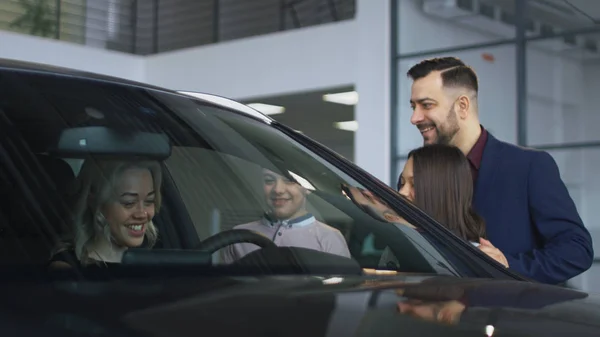 Bonne famille obtenir une nouvelle voiture dans le salon — Photo