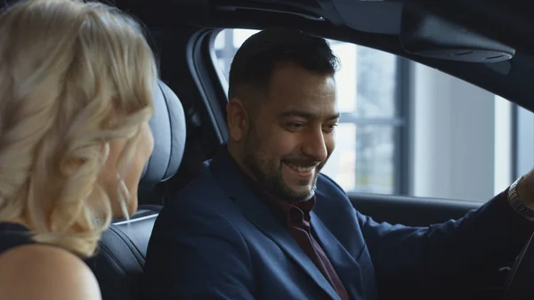 Exitosa pareja probando coche nuevo en el salón —  Fotos de Stock