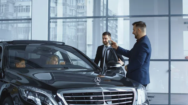 Negociante tirando foto da família em carro novo — Fotografia de Stock