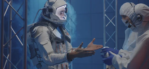 Científico ayudando a astronauta a ponerse guantes — Foto de Stock