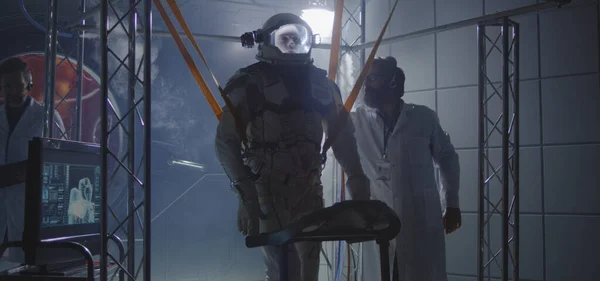 反重力バンドを宇宙飛行士に装着する科学者 — ストック写真